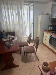 a kitchen with a table and two chairs and a table at Kay Borsa in Alba Iulia +8 photos