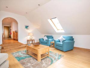 a living room with two blue chairs and a table at The Hive in Dornoch