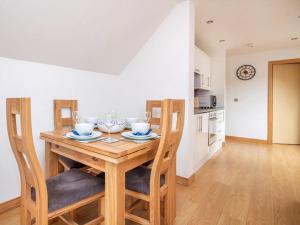 a kitchen and dining room with a wooden table and chairs at The Hive in Dornoch