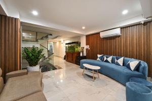 a living room with a blue couch and a fish tank at M Home Riverside in Ho Chi Minh City
