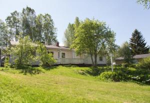 a house with a yard with grass and trees at Cozy Summerhouse by the River with free BIKES and ping pong in Rovaniemi