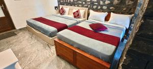 two beds sitting next to each other in a room at Elephant County Resort in Masinagudi