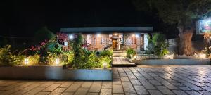 a building with lights in a courtyard at night at Elephant County Resort in Masinagudi