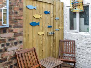 a wooden wall with shoes on it next to two chairs at Squirrel Cottage in Filey