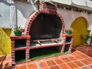 a brick oven with two potted plants on a patio at The Chill in Mansion Hostel Santa Marta in Santa Marta