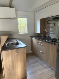a kitchen with wooden cabinets and a sink at mobilhome 5 personnes in Saint-Arnoult +4 photos