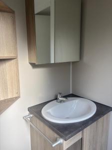 a bathroom with a sink and a mirror at mobilhome 5 personnes in Saint-Arnoult