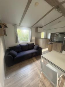a living room with a couch and a table at mobilhome 5 personnes in Saint-Arnoult
