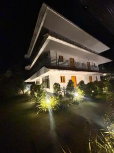 a large white building with lights in front of it at MJ paddy view Homestay in Kumarakom