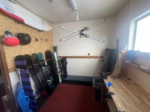 a room with a bunch of skis on the wall at Togari Sunshine Lodge in Iiyama