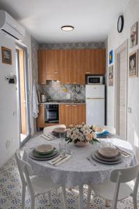 a kitchen with a table with plates and flowers on it at Soleil Apartment - Zona Ospedale Pederzoli in Peschiera del Garda