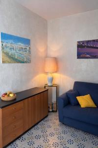 a living room with a blue couch and a lamp at Soleil Apartment - Zona Ospedale Pederzoli in Peschiera del Garda