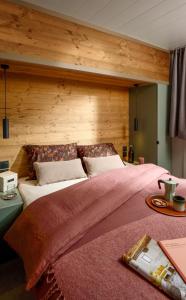 a bedroom with a large bed with a wooden wall at VVF Aubrac in Chaudes-Aigues +35 photos