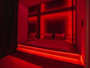 a red room with a bed in a window at L'unique - Love-room Romantique in Angoulême