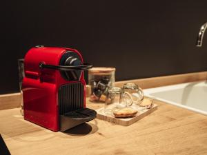 a red toaster sitting on a counter next to a sink at L'unique - Love-room Romantique in Angoulême