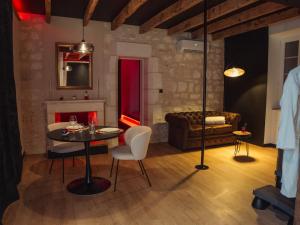 a living room with a table and a couch at L'unique - Love-room Romantique in Angoulême