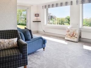a living room with two chairs and two windows at Repentance View in Carrutherstown