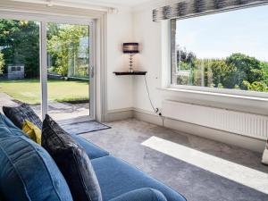 a living room with a blue couch and a window at Repentance View in Carrutherstown