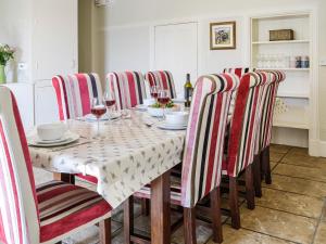 a dining room with a table and chairs with wine glasses at Repentance View in Carrutherstown +25 photos