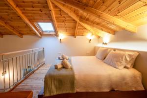a bedroom with a large bed in a room with wooden ceilings at Pavliani Aesthesis by Raise in Pavliani