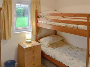 a bedroom with two bunk beds and a window at Tregunna Cottage in Wadebridge