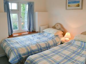 a bedroom with two beds and a window at Tregunna Cottage in Wadebridge