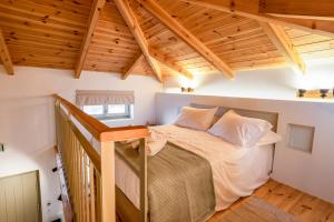 a bedroom with a bed in a room with wooden ceilings at Pavliani Aesthesis by Raise in Pavliani