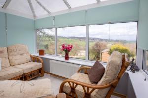 a living room with two chairs and a window at Fall in Green in Haworth