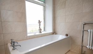 a bath tub in a bathroom with a window at Fall in Green in Haworth +9 photos