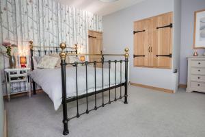 a bedroom with a bed and a wooden cabinet at Fall in Green in Haworth