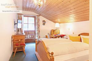 a bedroom with a large bed with a wooden ceiling at Edelweißhof in Ischgl