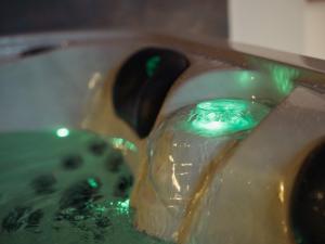 a glass bottle in a sink with green liquid at L'unique - Love-room Romantique in Angoulême