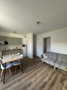 a living room with a couch and a table at Le Nid de la Mayenne in Mayenne