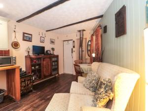 a living room with a couch and a tv at Sammy Hakes Cottage in Watchet