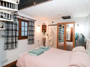 a bedroom with a bed with two towels on it at Sammy Hakes Cottage in Watchet