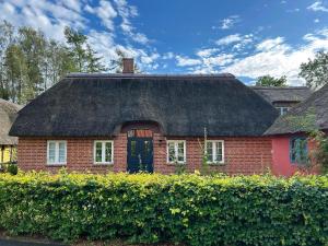 a red brick house with a thatched roof at Idyllic House By Mossø in Skanderborg