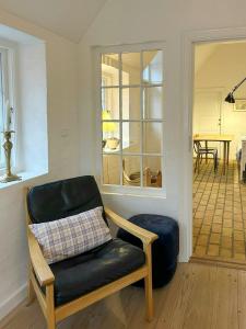 a living room with a chair and a table at Idyllic House By Mossø in Skanderborg +16 photos