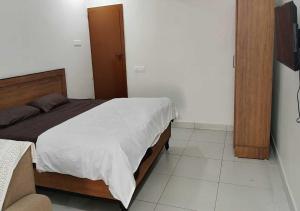 a bedroom with a bed and a television in it at Kostha Suites in Anumalkudūru
