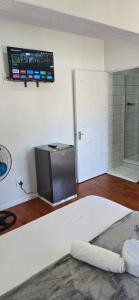 a room with a tv on the wall next to a door at Ridah's Accomodation in Bellville