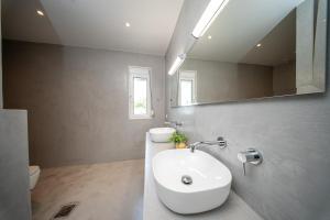 a white bathroom with a sink and a mirror at Villa Aionia in Lepeda in Lixouri