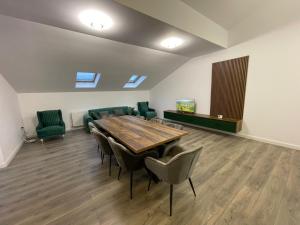 a conference room with a wooden table and green chairs at Rădăuți Residence 3 in Rădăuţi