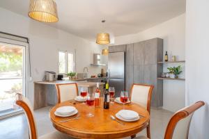 a dining room table with glasses of wine on it at Villa Aionia in Lepeda in Lixouri