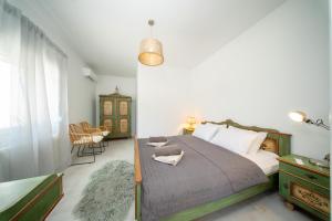 a bedroom with a bed and a chair in it at Villa Aionia in Lepeda in Lixouri