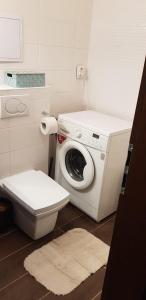 a bathroom with a washing machine and a toilet at Apartman Zvolen in Zvolen