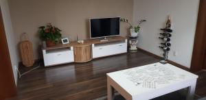 a living room with a flat screen tv and a table at Apartman Zvolen in Zvolen