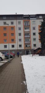 a person walking down a sidewalk with an umbrella at Apartman Zvolen in Zvolen +1 photo
