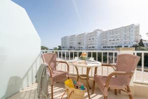 a patio with a table and chairs on a balcony at Apartamentos Playa Marina in Cala Ferrera