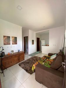 a living room with a couch and a kitchen at Suíte na praia do amor in Conde
