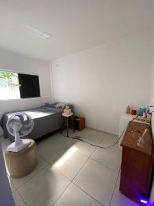 a bedroom with a bed and a desk with a fan at Suíte na praia do amor in Conde +5 photos