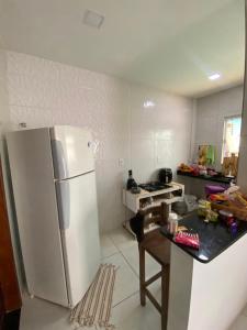 a kitchen with a refrigerator and a table in it at Suíte na praia do amor in Conde